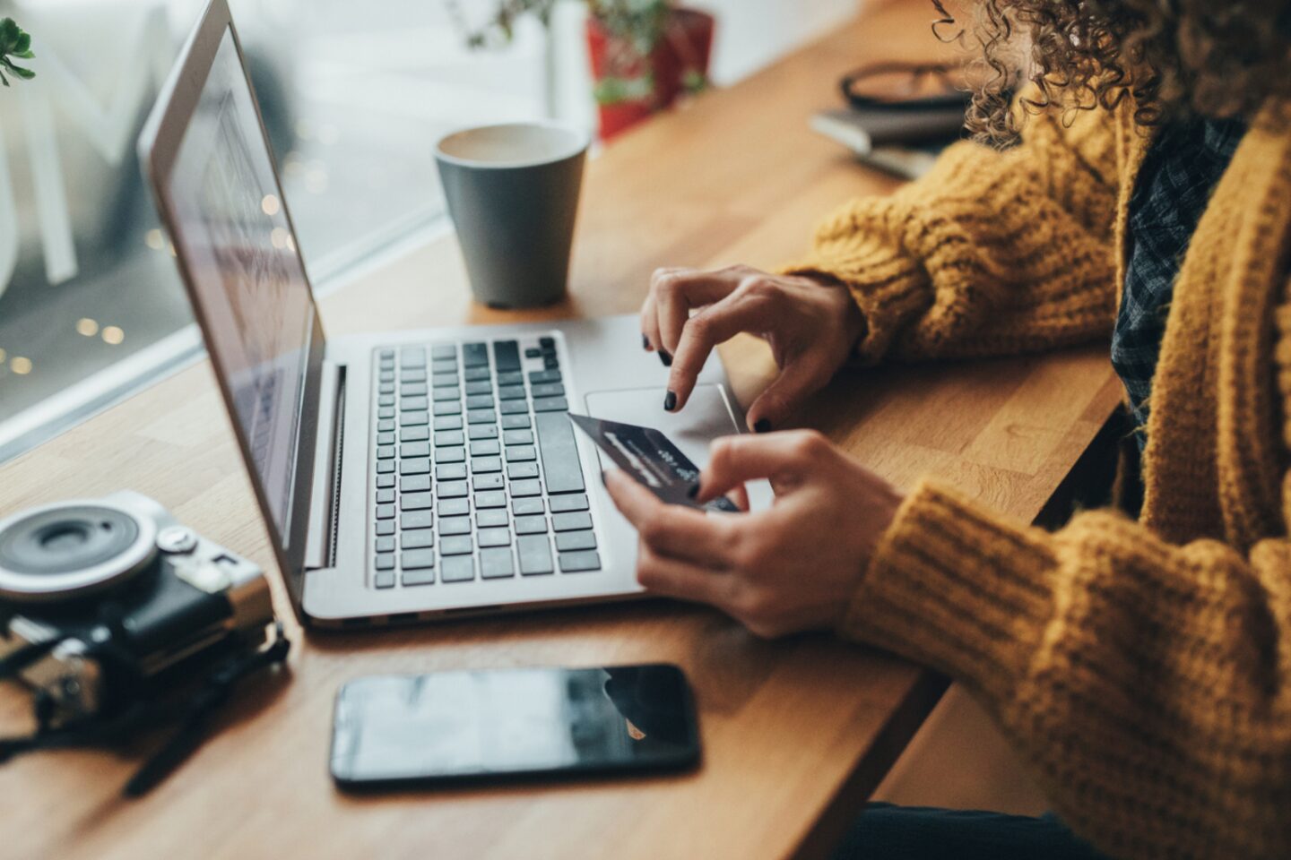 Person typing in credit card information on laptop