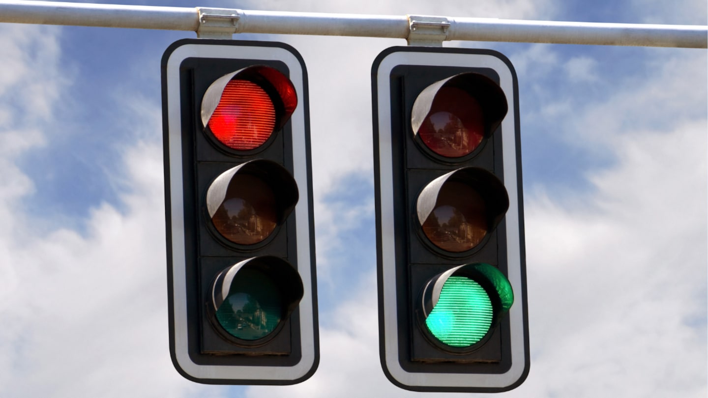 two stop lights with one red and one green